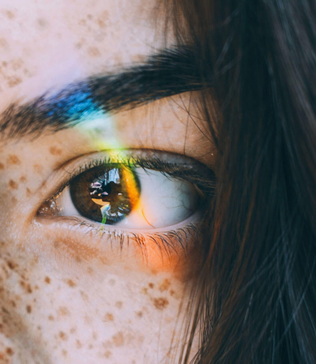 Freckled women hazel eye, light glared retina showing clutter from clean, colour from bland, & ego from pride phases of branding